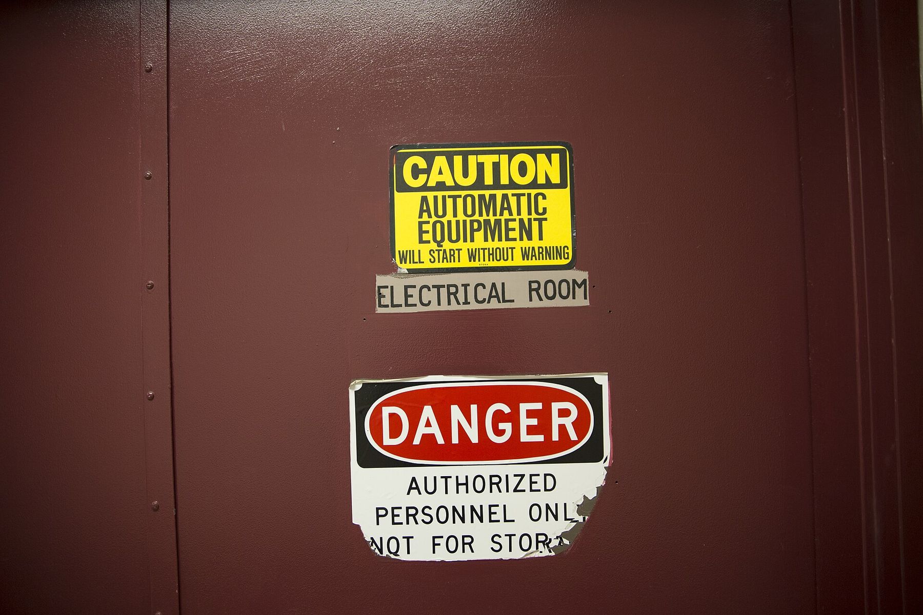 Caution and danger signs on an electrical room door