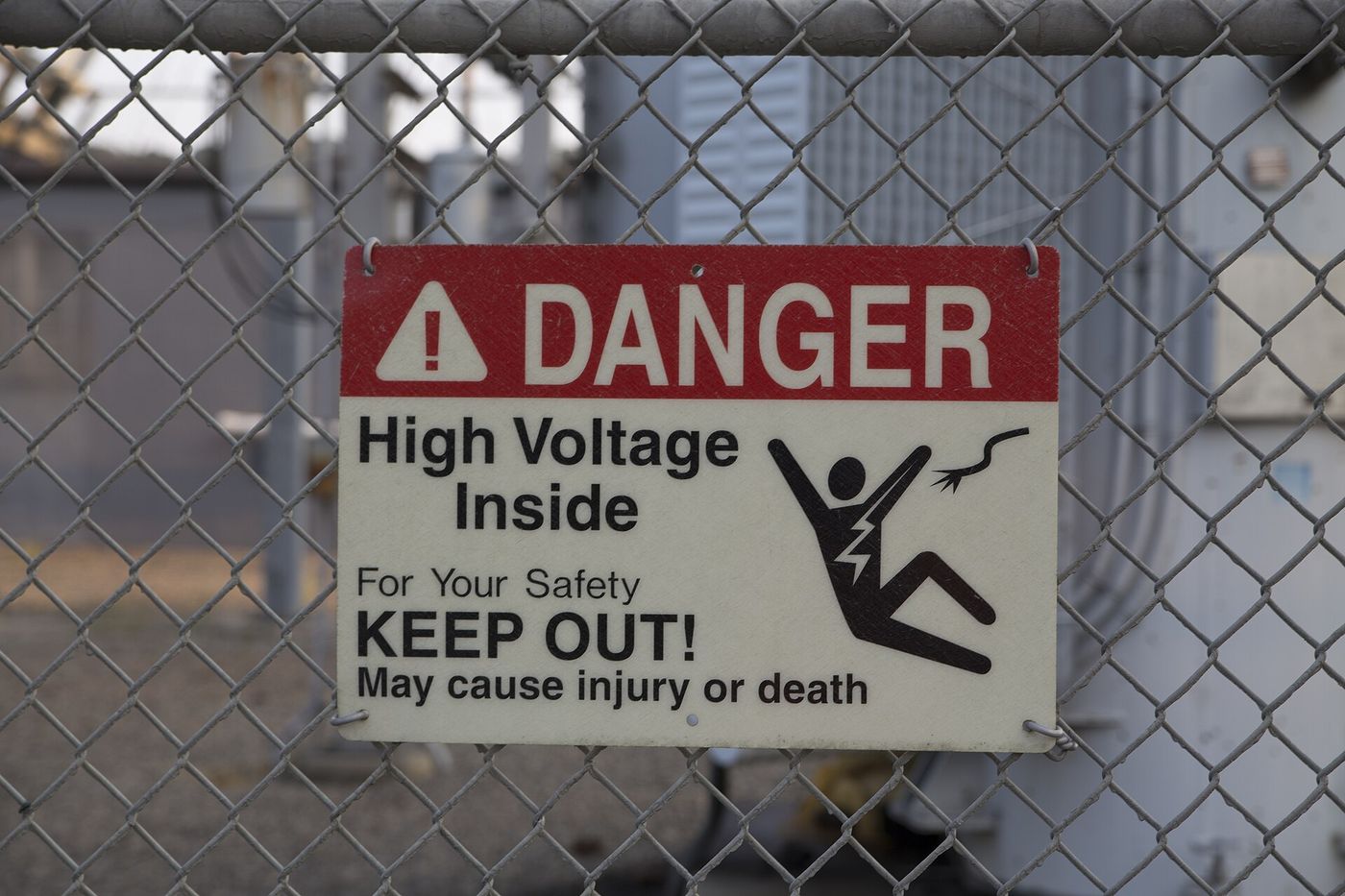 Danger high voltage sign on a chain link fence